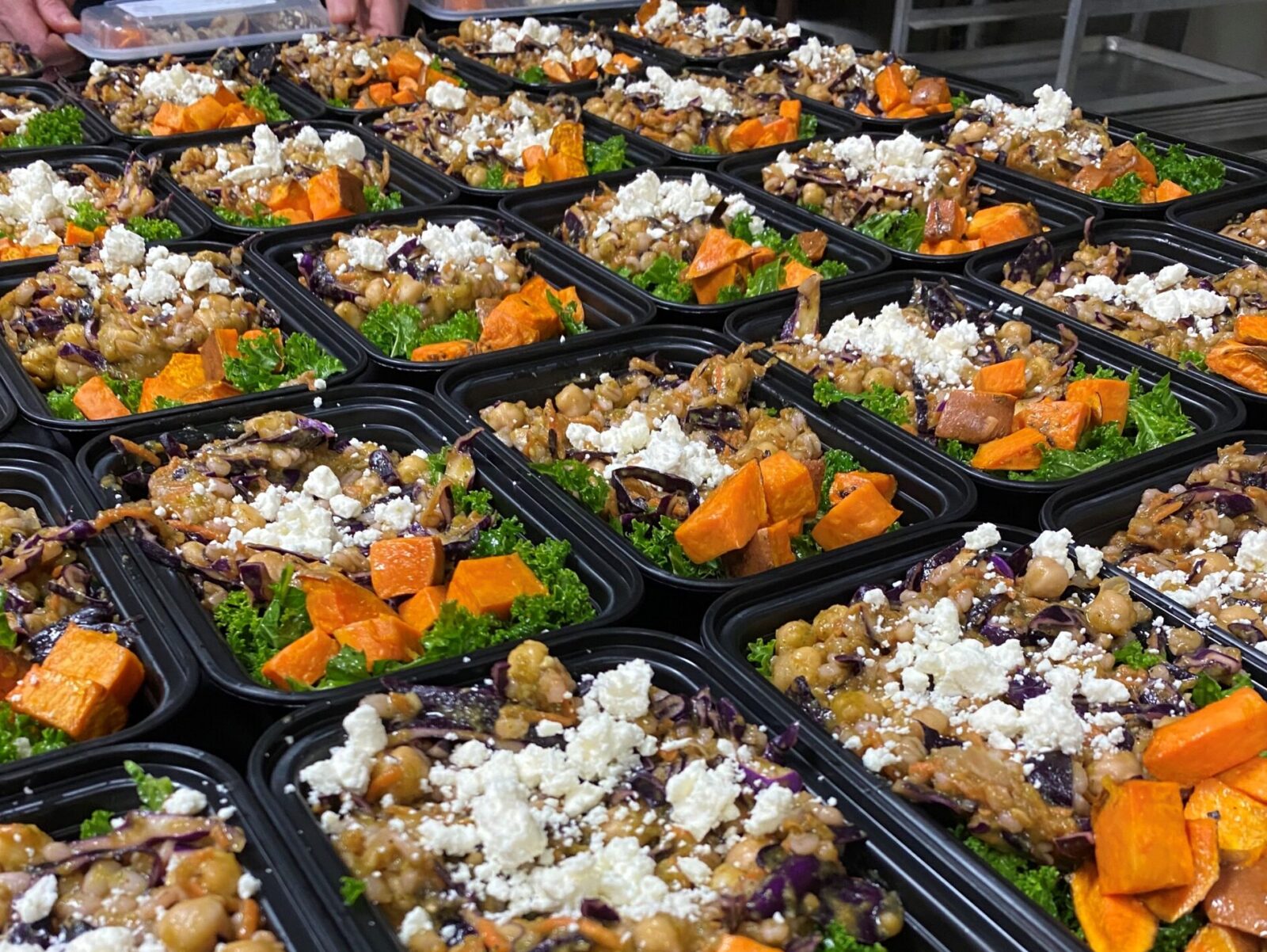 Prepared food in portable containers lined up on a table
